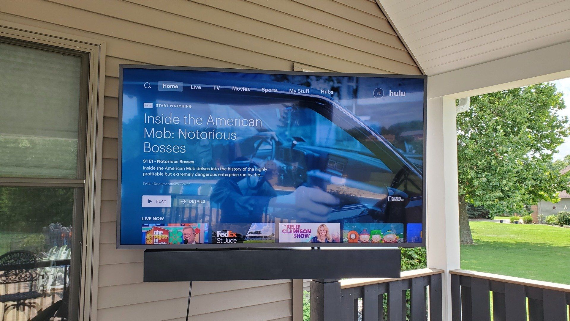 a samsung terrace outdoor television is mounted in a patio area with an outdoor soundbar below it