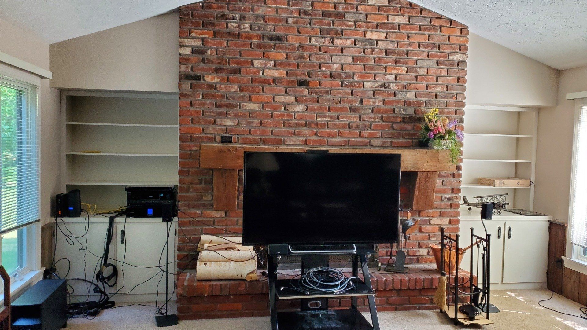 a living room with a brick fireplace and a flat screen tv mounted to a fireplace with tv mounting by fisher electronics in northern ohio
