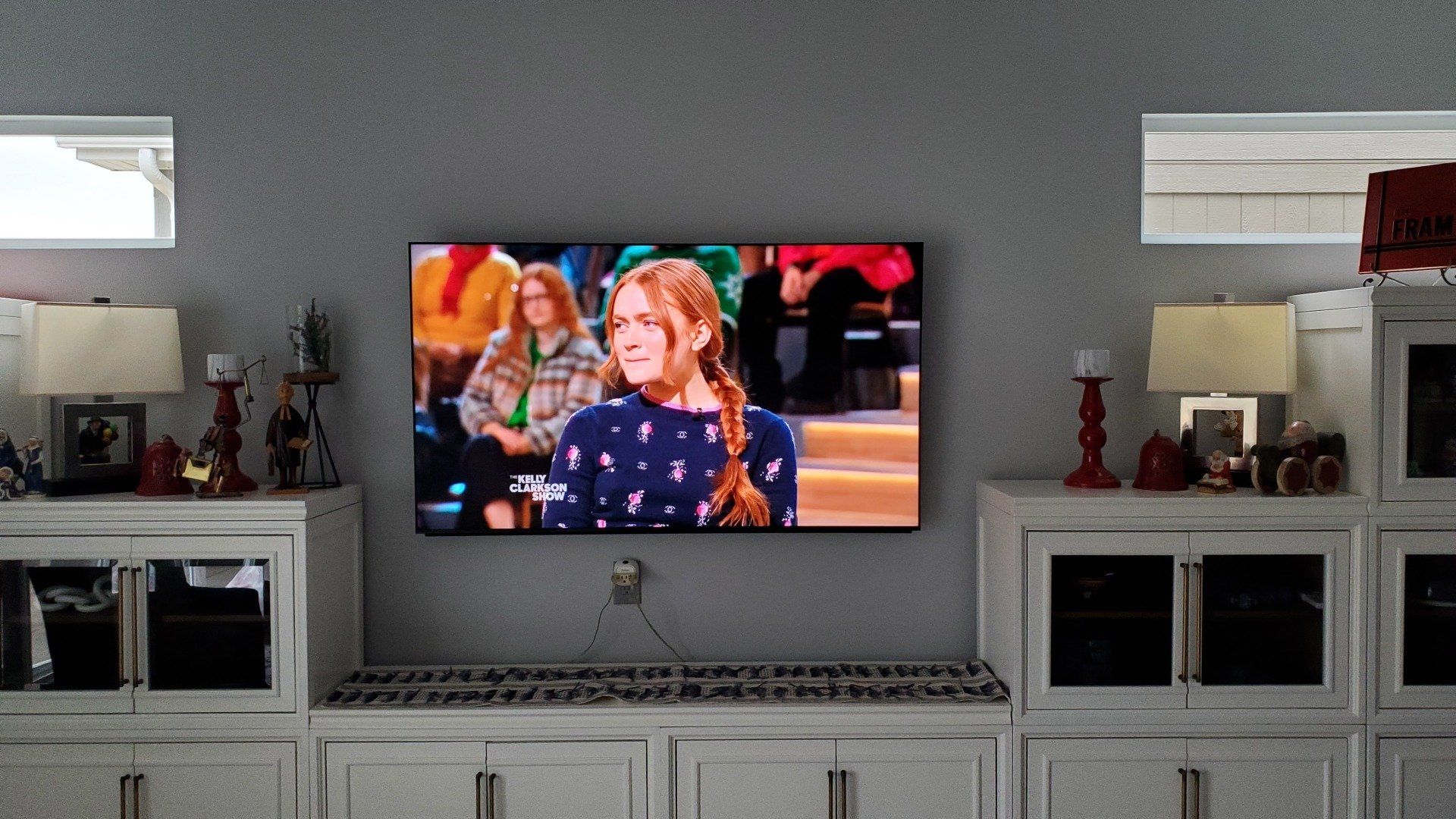 a tv is mounted flat on the wall above an entertainment cabinet in vermilion ohio