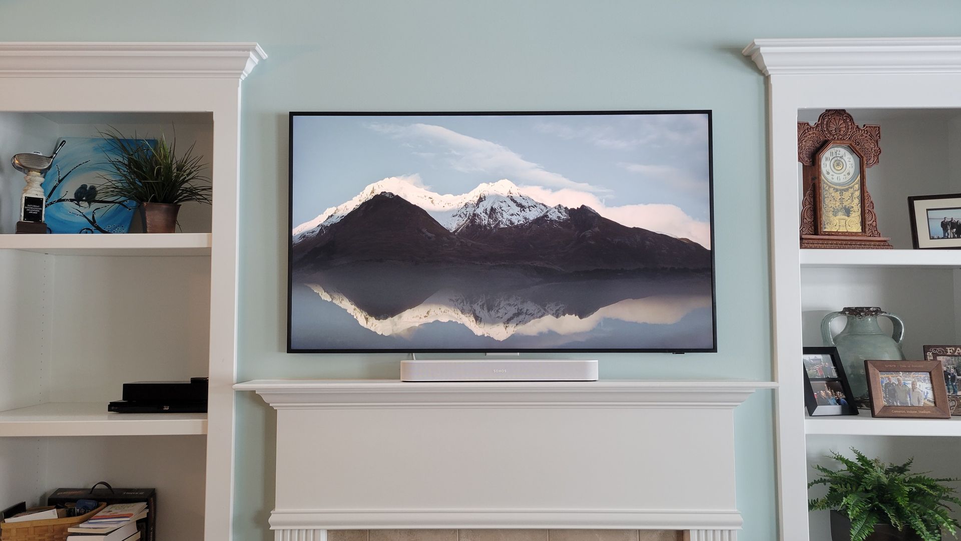 A samsung frame TV is mounted above a fireplace in a living room