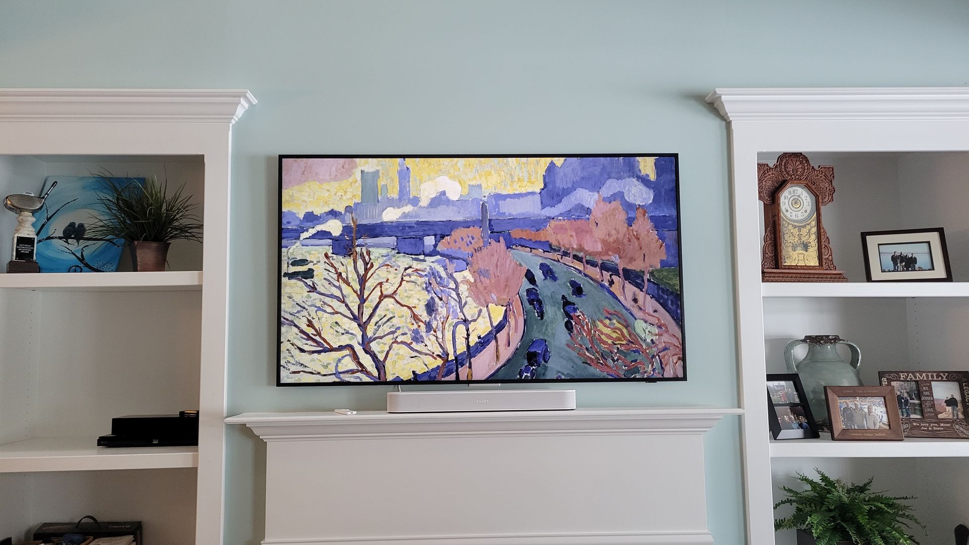 A samsung frame TV is mounted above a fireplace in a living room