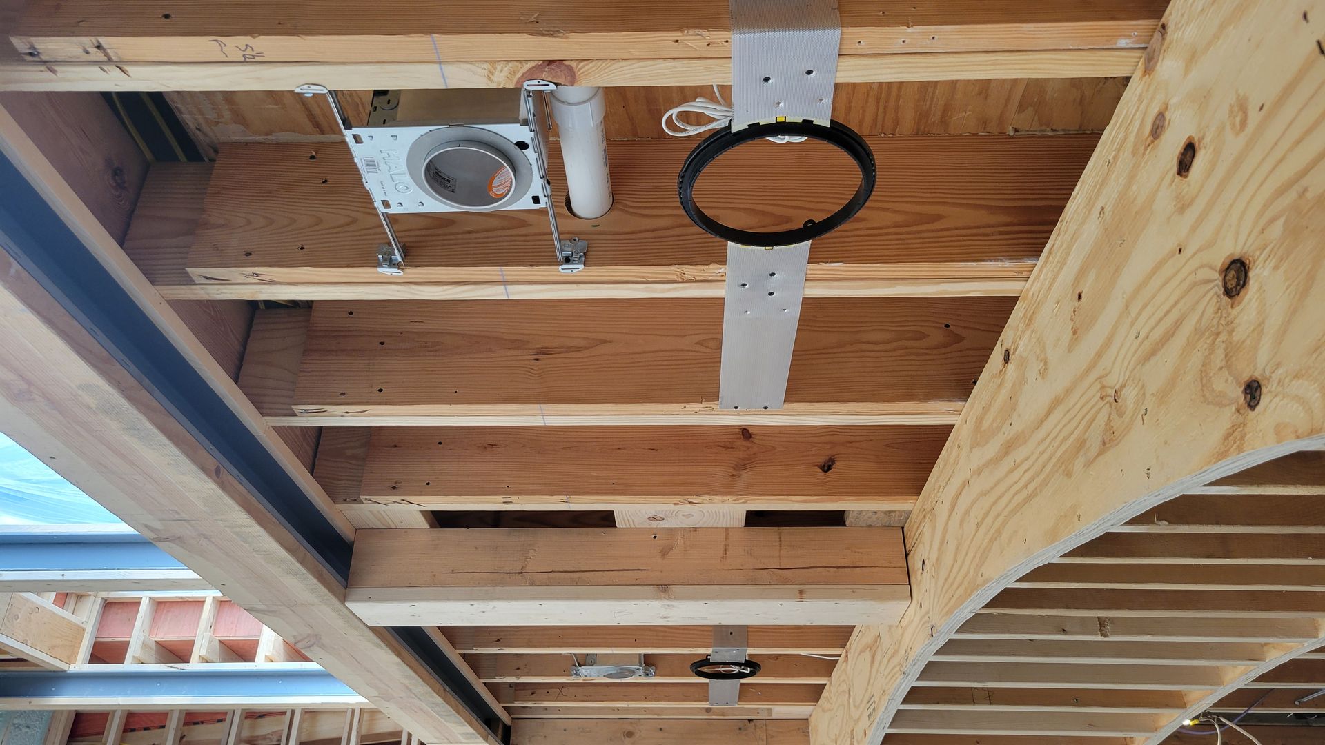 A wooden ceiling with custom speaker brackets installed for home audio.