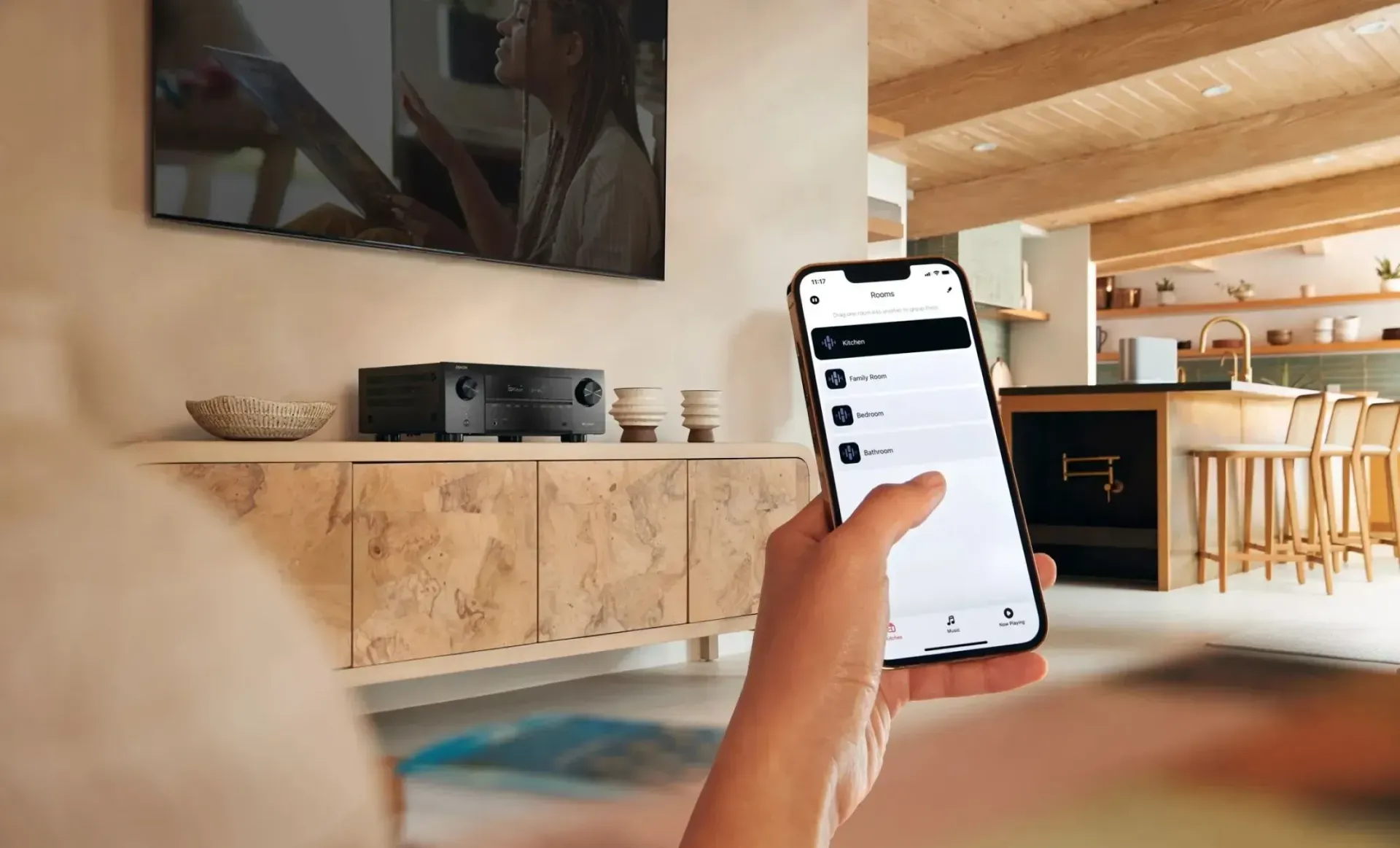 A person is using a smart phone app to control a whole home audio system