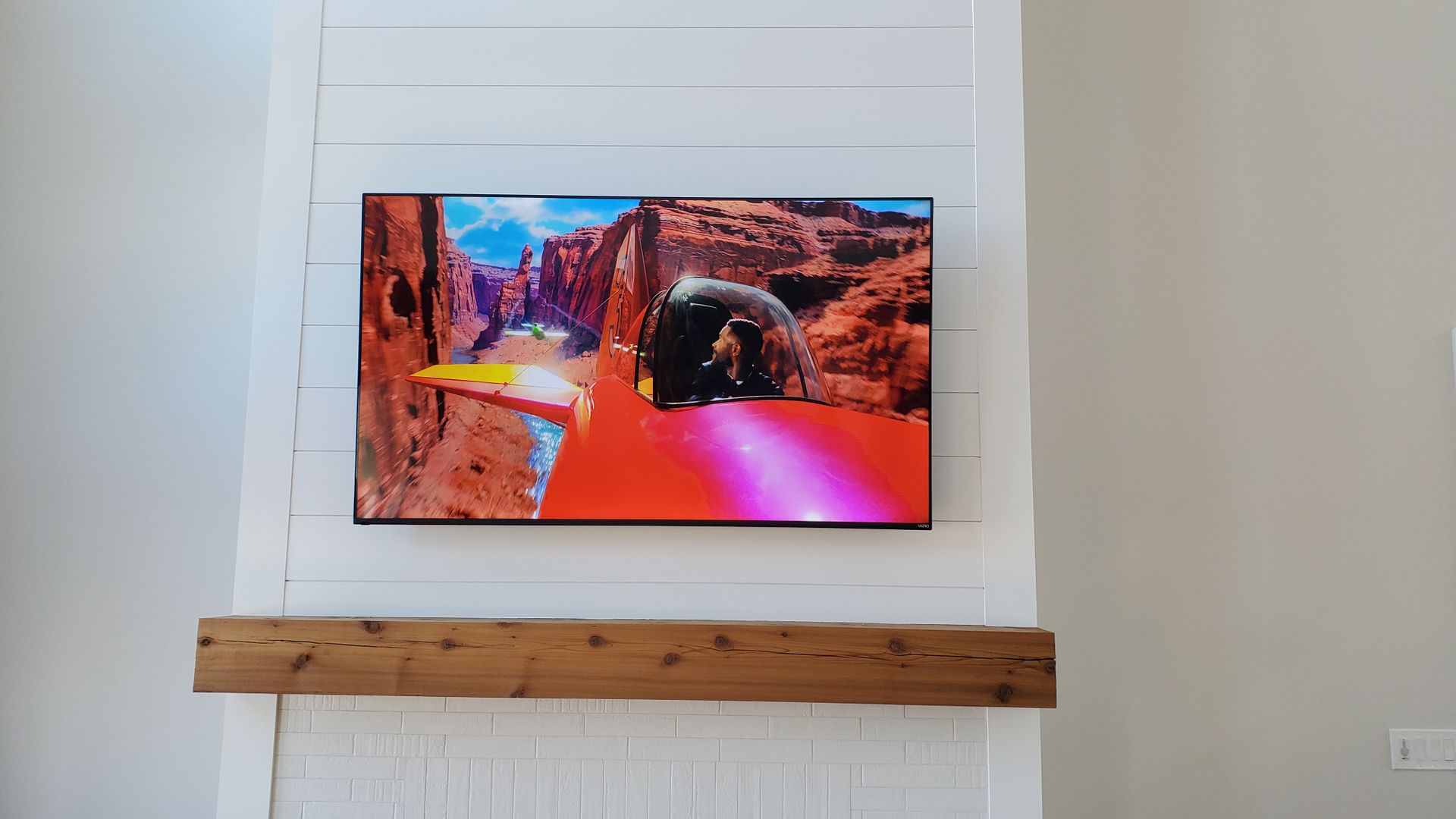 a tv mounted on a wall above a fireplace mantle in northern ohio