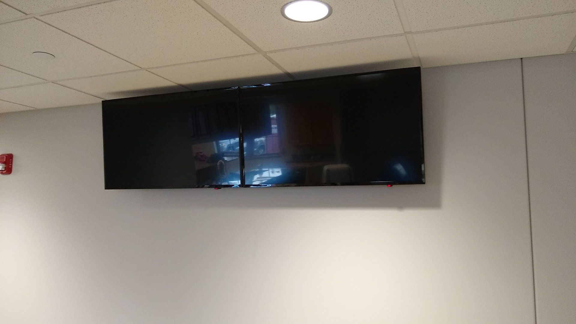 two flat screen TVs are mounted on a wall side by side in north central ohio