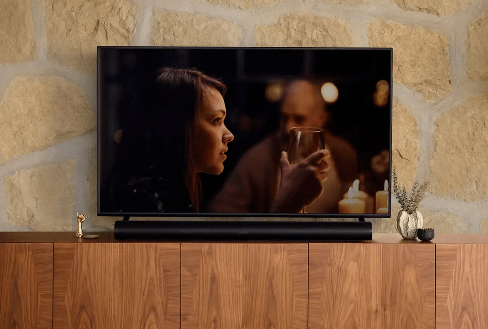 a tv shows a woman holding a glass of wine and speaking clearly with detail from the sonos arc soundbar sold by fisher electronics in northern ohio
