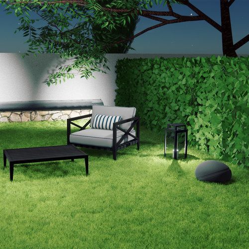 a lawn with a couch , chair , table and rock speaker for outdoor audio.