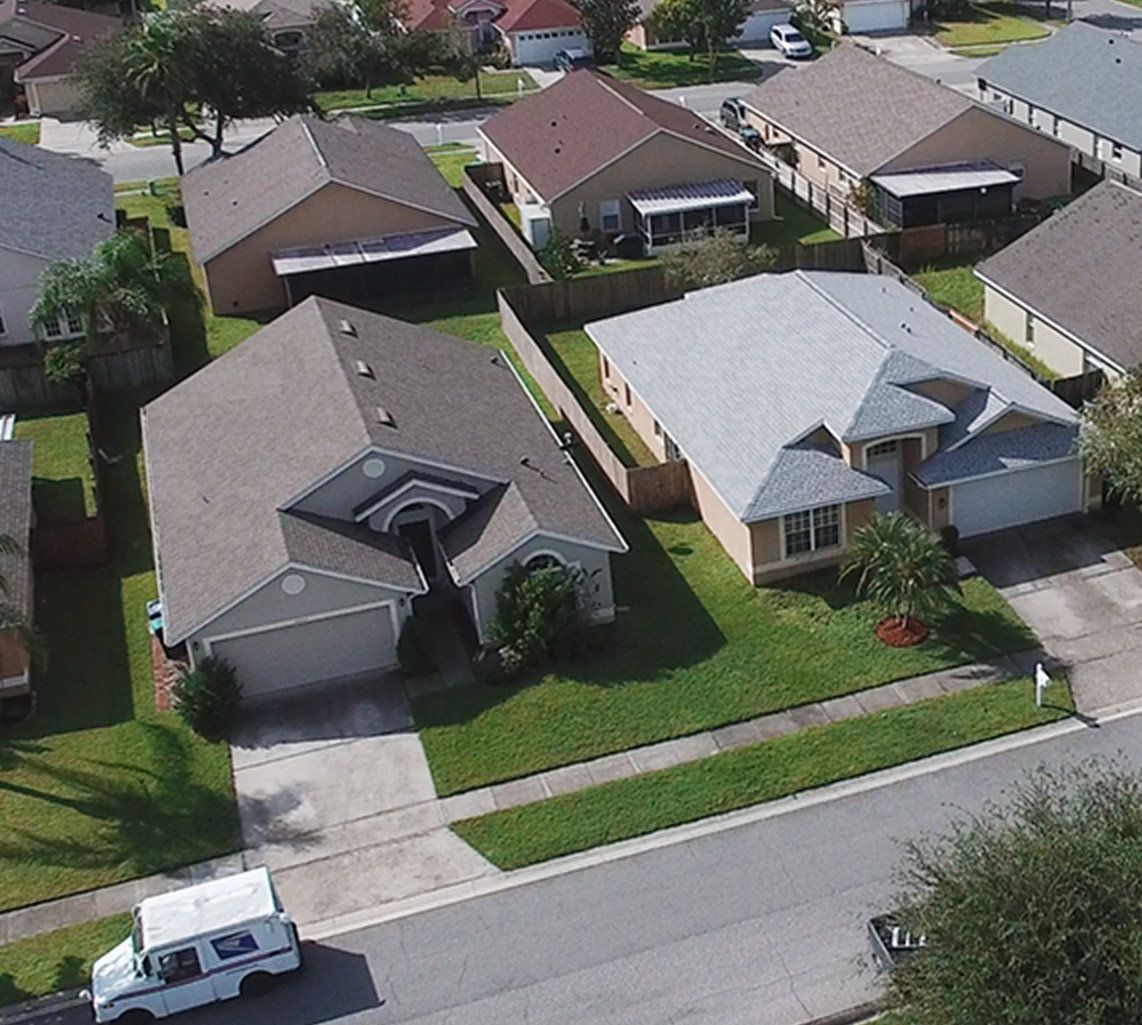 An aerial view of a residential neighborhood with houses and a mail truck