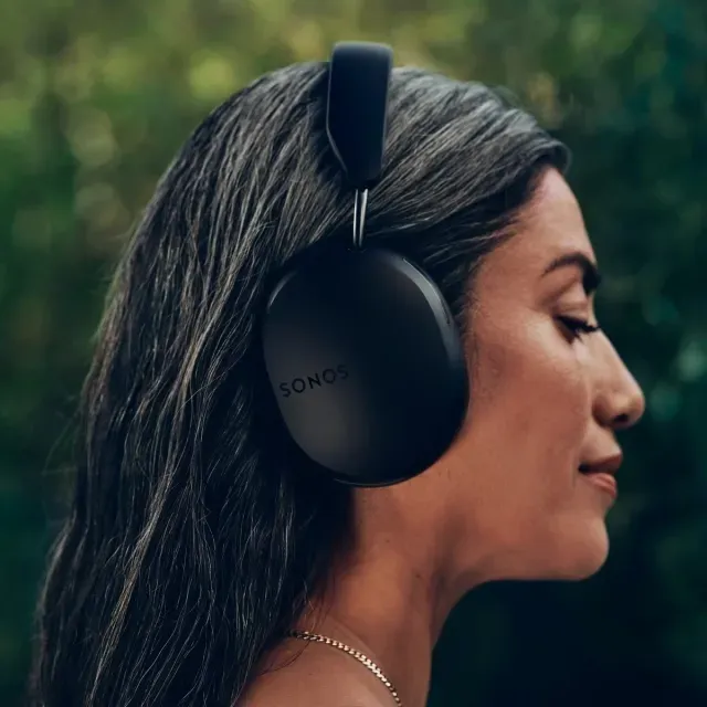 A woman is wearing sonos headphones and listening to music.