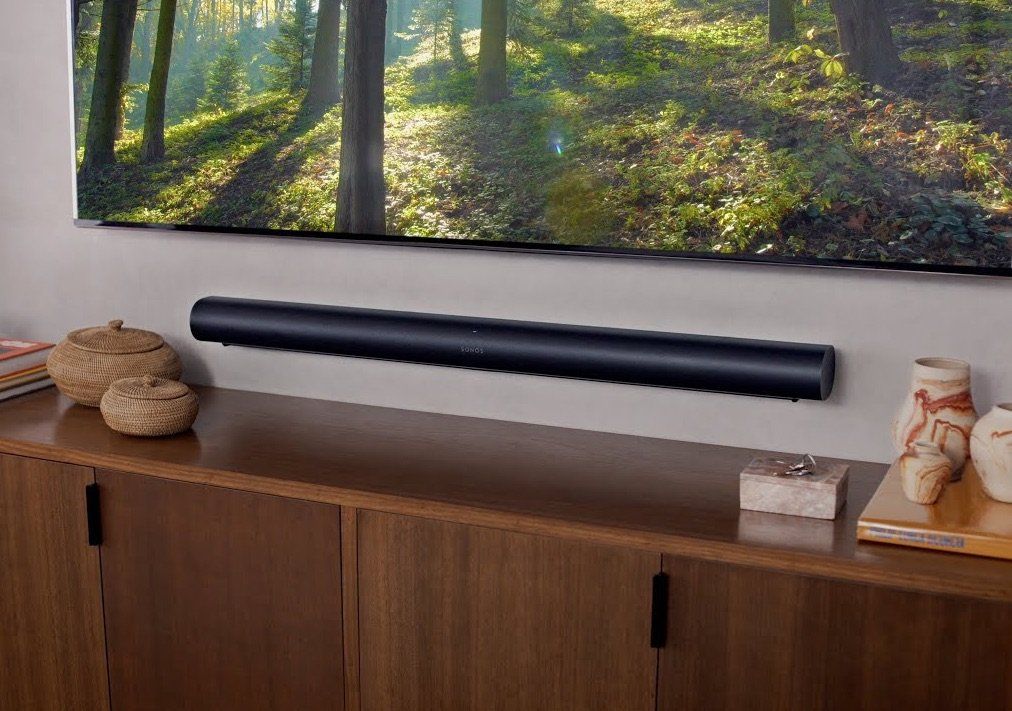 a sonos arc soundbar is mounted to the wall above a wooden cabinet by fisher electronics in northern ohio