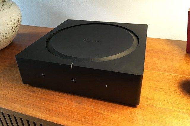 a sonos amp is sitting on top of a wooden table