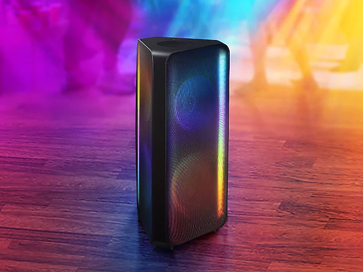 a samsung bluetooth sound tower speaker is sitting on a wooden floor in front of a colorful background