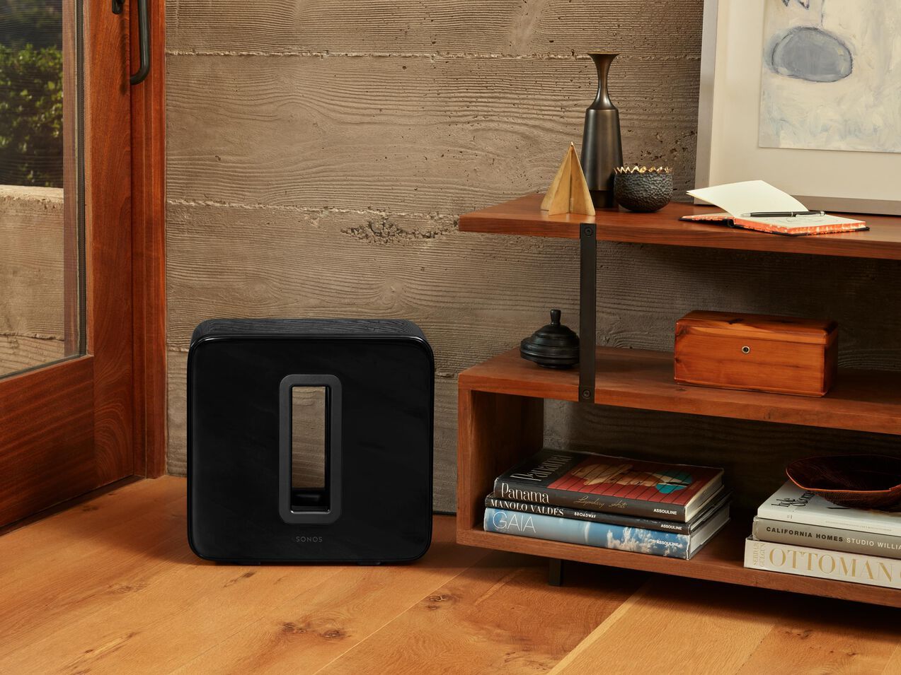 a black sonos sub sits on a wooden floor installed and sold by fisher electronics in norwalk ohio