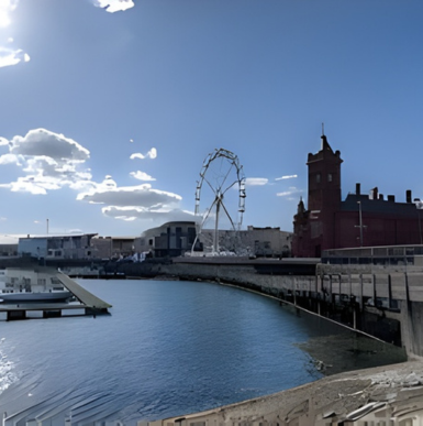 Waterfront view of Cardiff Bay with boats, promenade, and modern buildings
