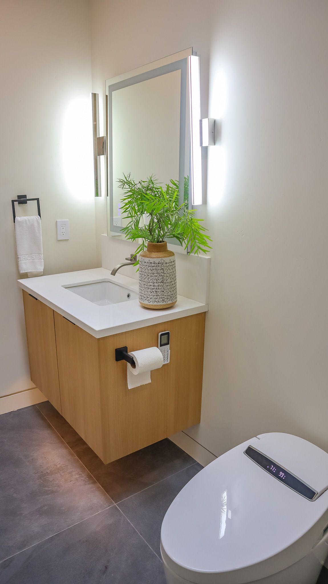 Modern bathroom with a floating vanity, lit mirror, and bidet toilet.