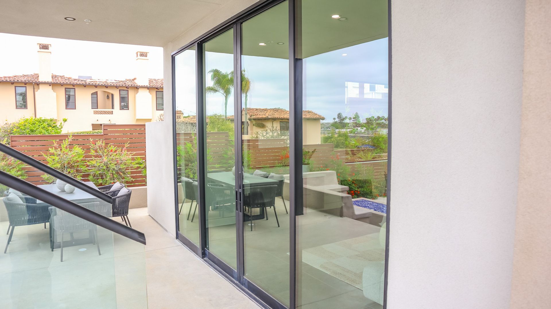 Sliding glass doors open to a patio with a table, chairs, and other outdoor furniture.