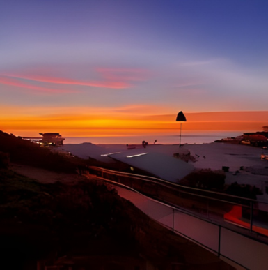 Sandy beach with volleyball courts and families enjoying sunset at Moonlight State Beach