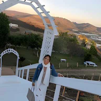 Vineyard rows with tasting patio, rolling hills, and scenic mountain views at Sunshine Mountain Vineyard