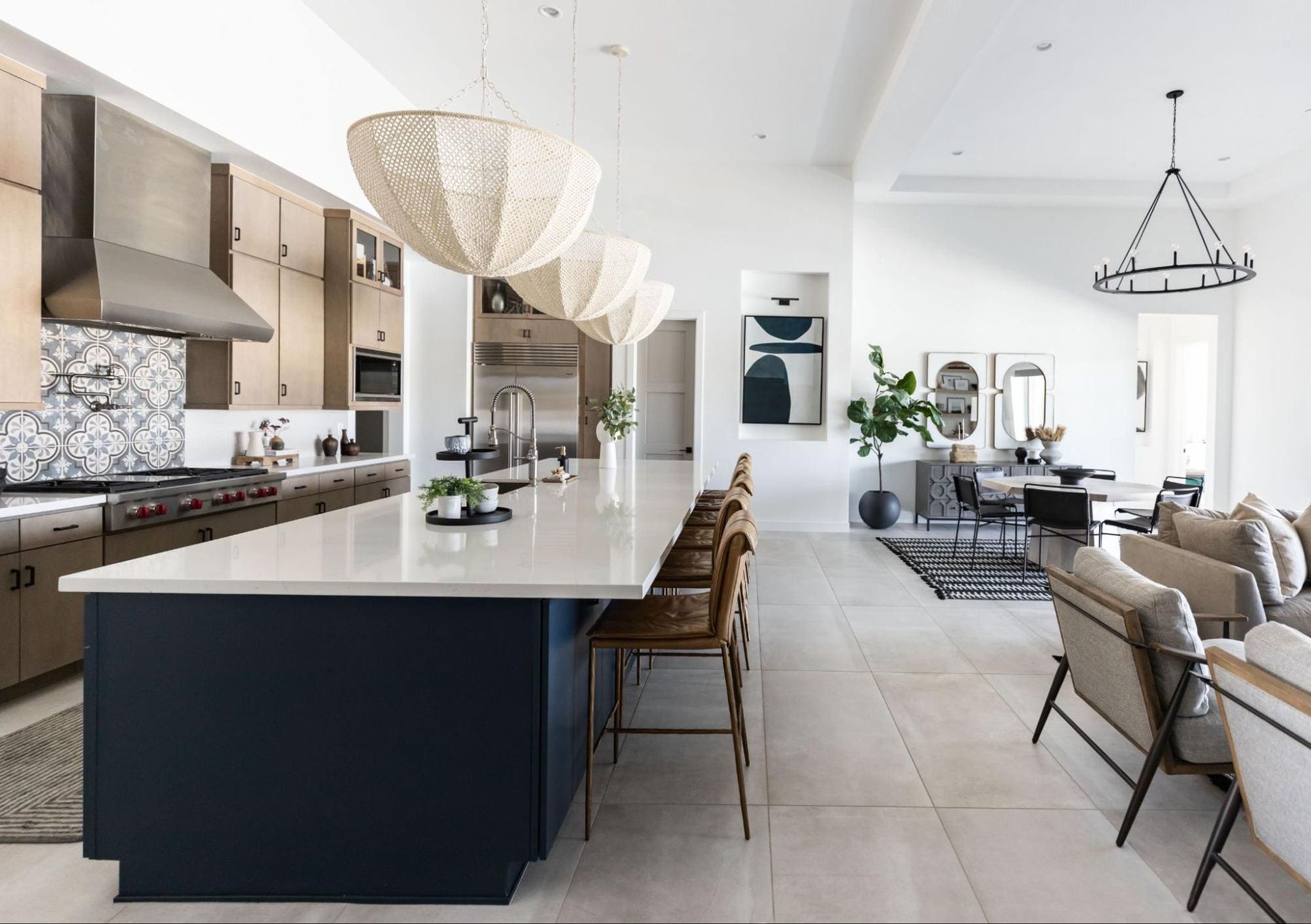 Modern kitchen with navy island, light cabinets, and open layout to living area.