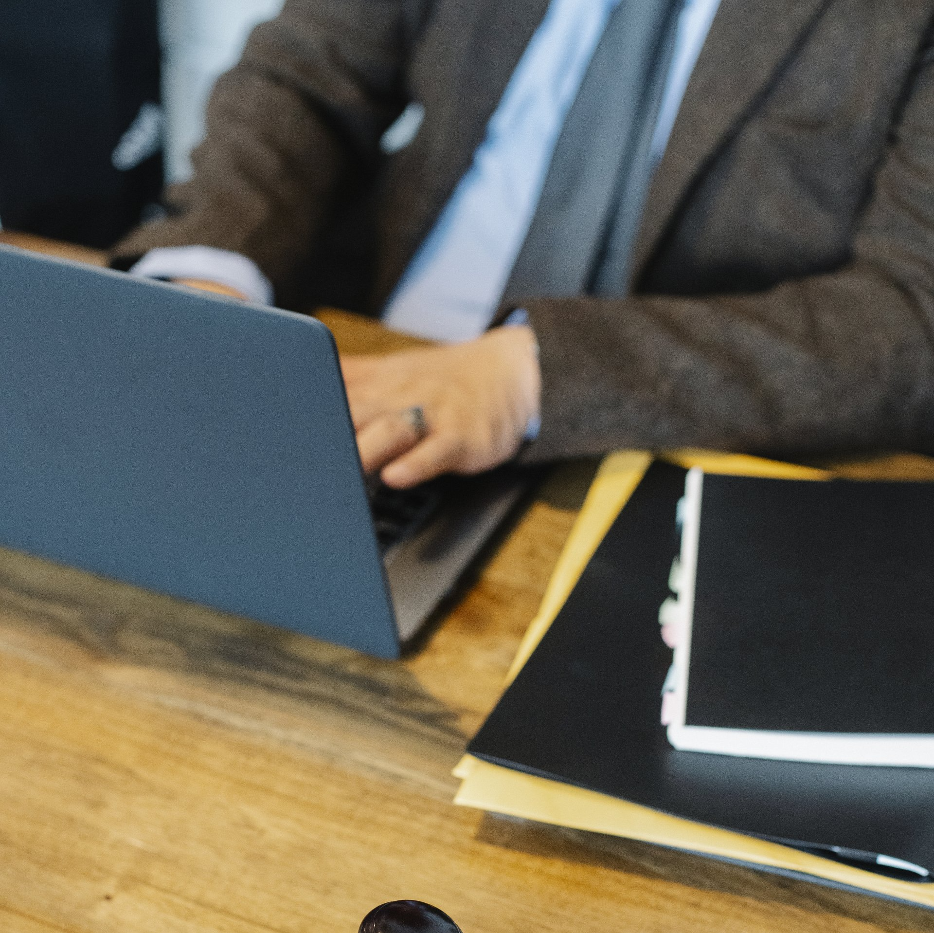 Una persona vestida con un traje marrón trabaja en un ordenador portátil 