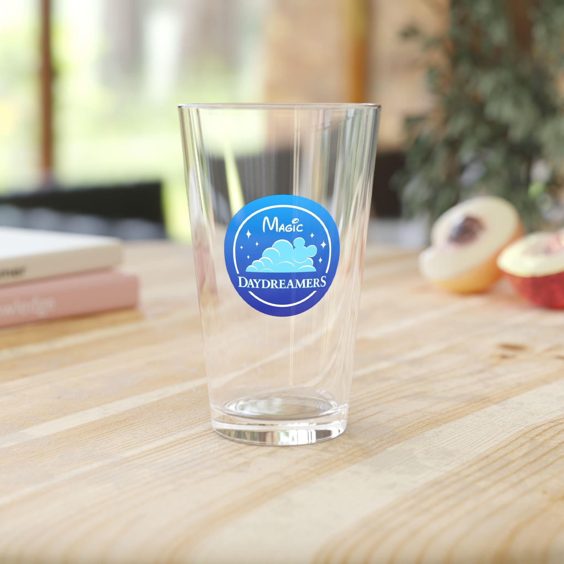 A clear glass with a blue sticker that  says music dreamers merch