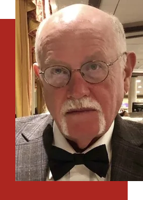 The man is wearing glasses and a bow tie.