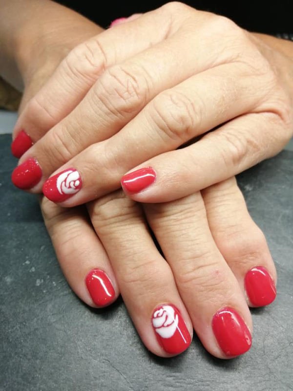 Smalto rosso con disegno di rosa bianca sugli indici.