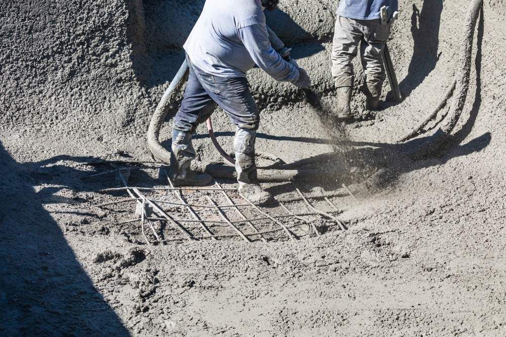 Worker Spraying Concrete onto Rebar Grid on Construction Site — Coastcrete Concrete Specialist in Taylors Beach, NSW