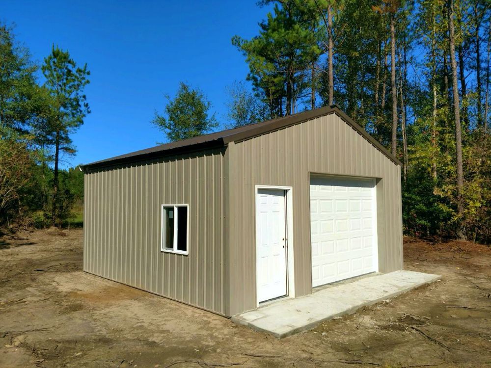 Tan metal garage with brown roof, white door, window, and garage door on a concrete pad.