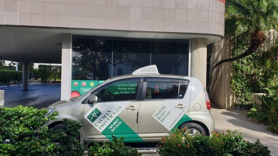 A White and Green Car is Parked in Front of a Building
