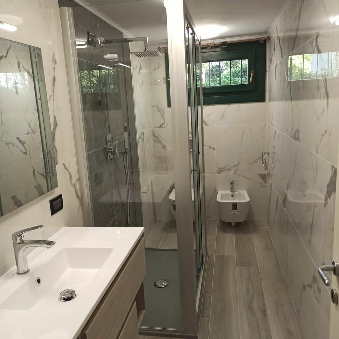 Un bagno con lavandino, wc e doccia.