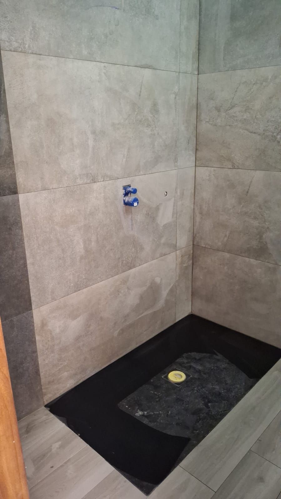 Un bagno con cabina doccia e pareti piastrellate.