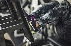 A person is using a leg press machine in a gym.