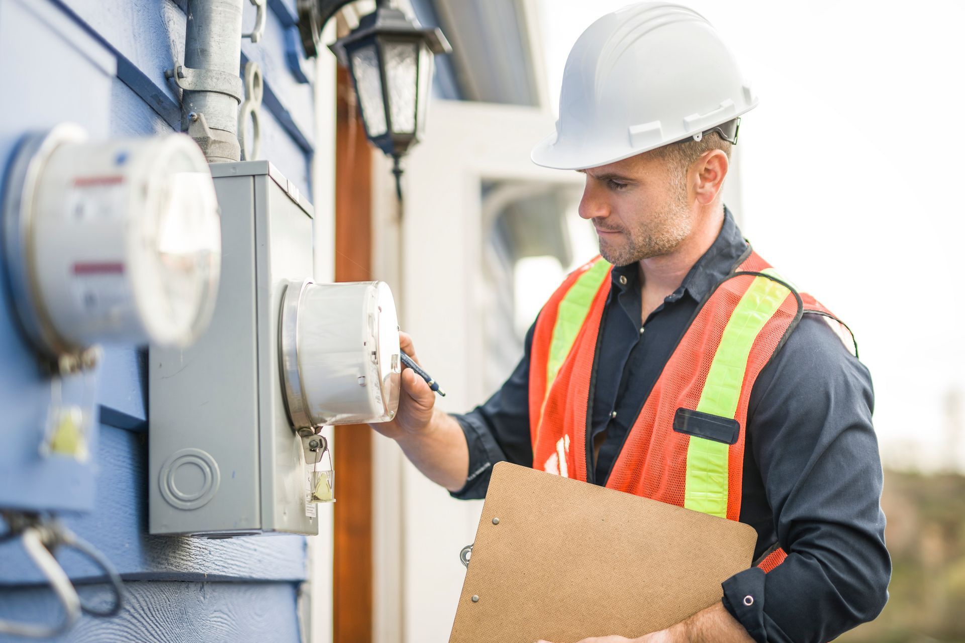 Man with hard hat standing in front of a electric panel.