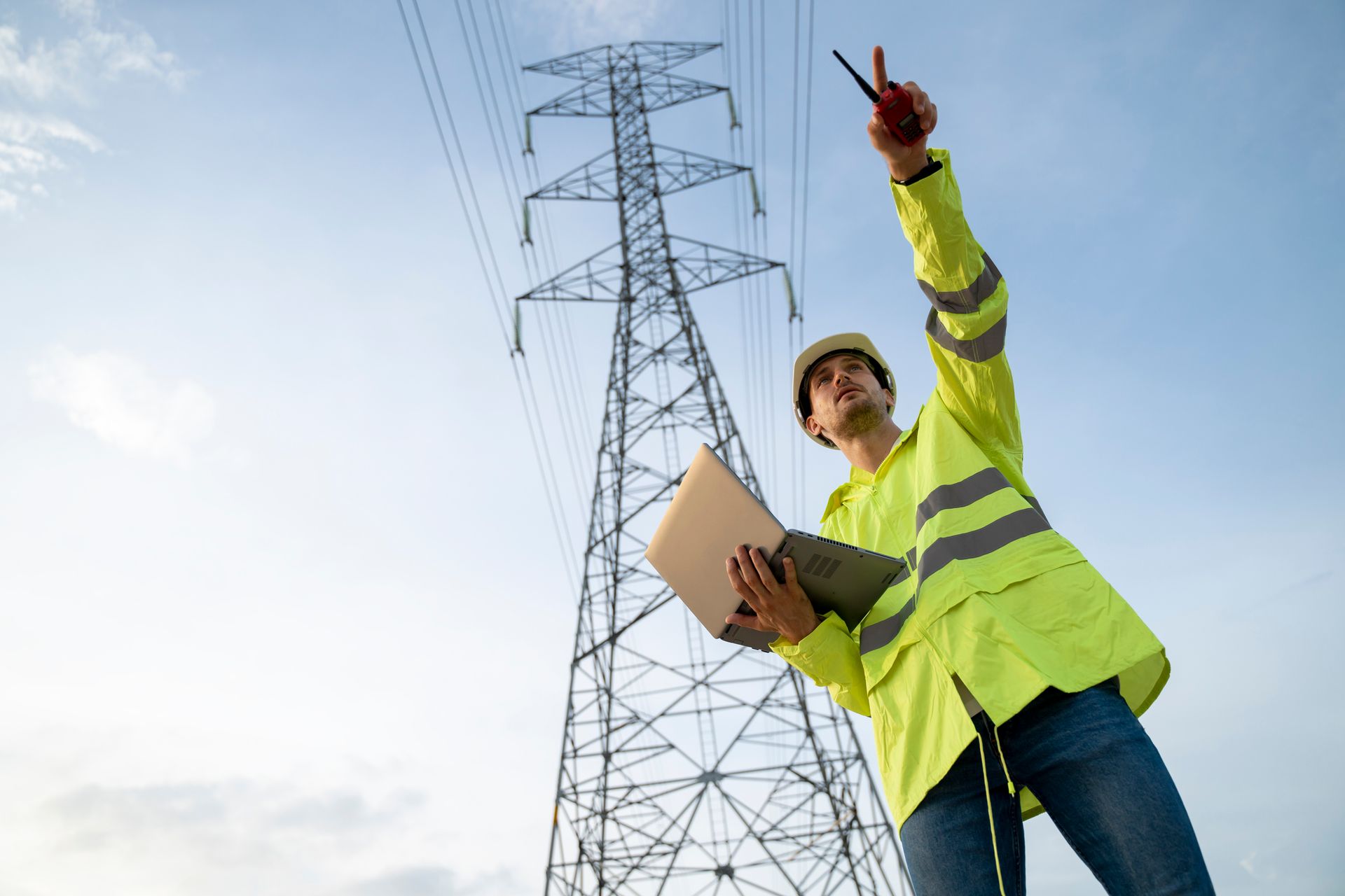 Electrical engineer with safety uniform working blueprint drawing