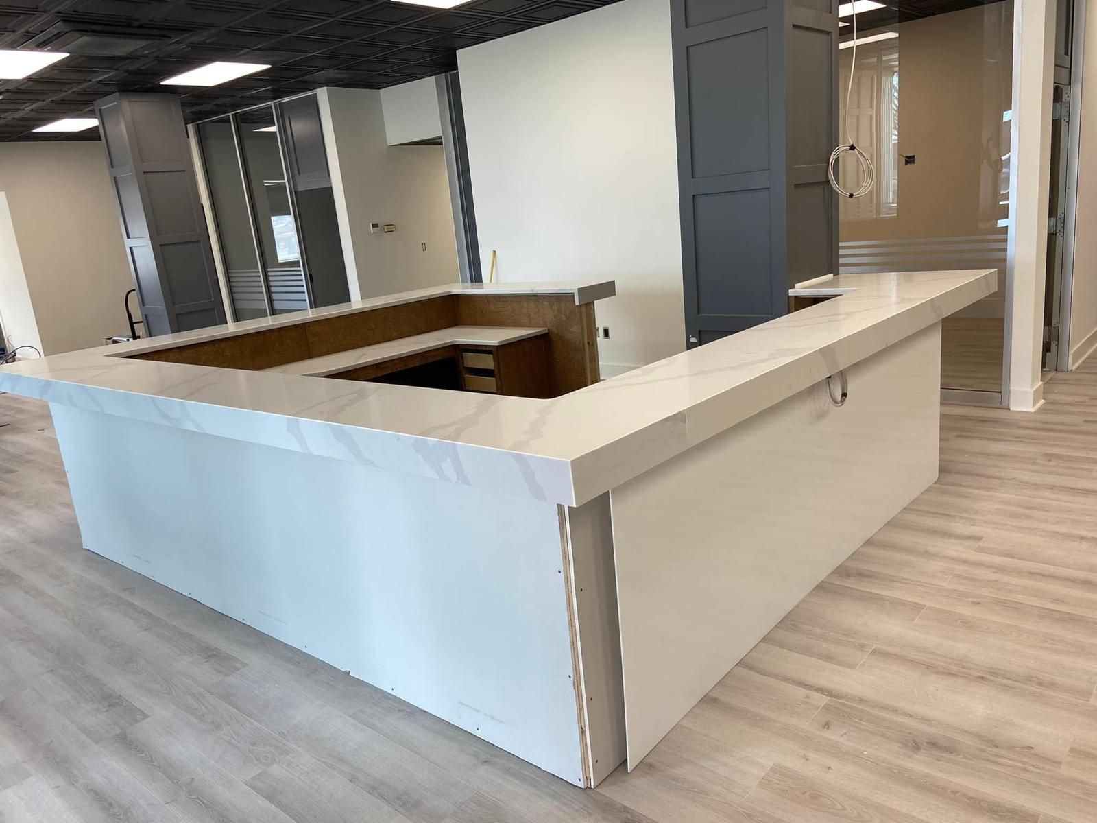 White and gray kitchen island with a light countertop, under construction.