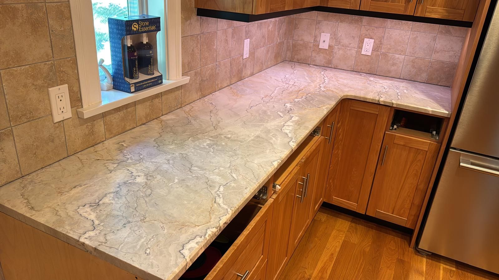 Kitchen with light-colored granite countertop, wooden cabinets, and a tile backsplash