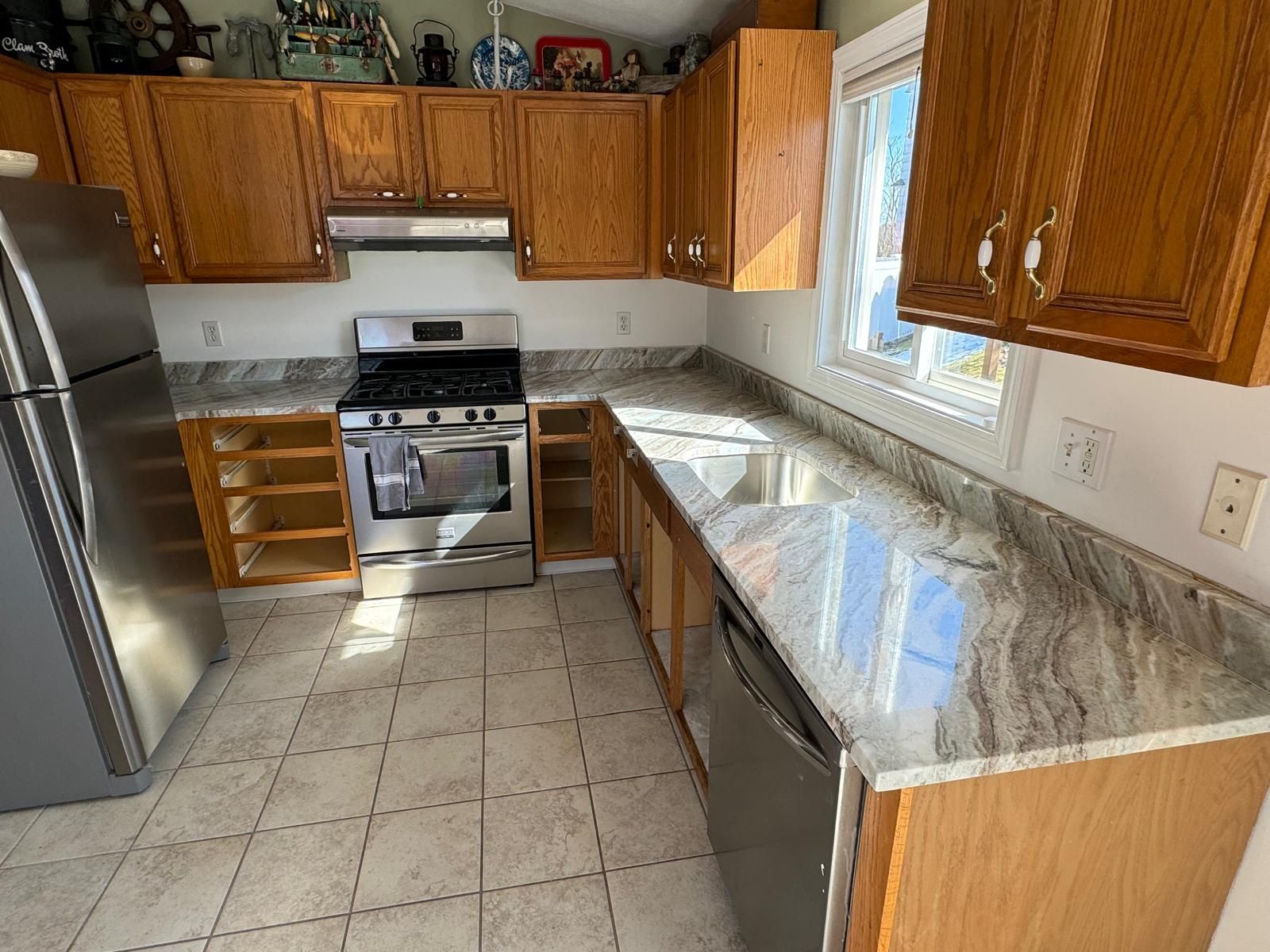 Kitchen with wood cabinets, stainless steel appliances, and granite countertops.