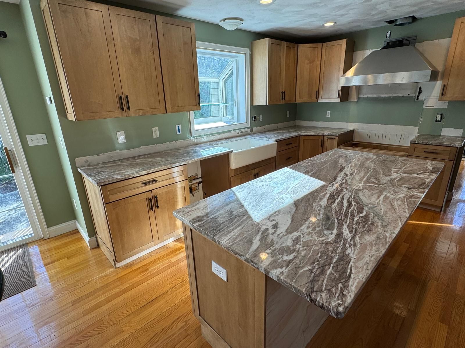 Kitchen with light wood cabinets, granite countertops, and an island.