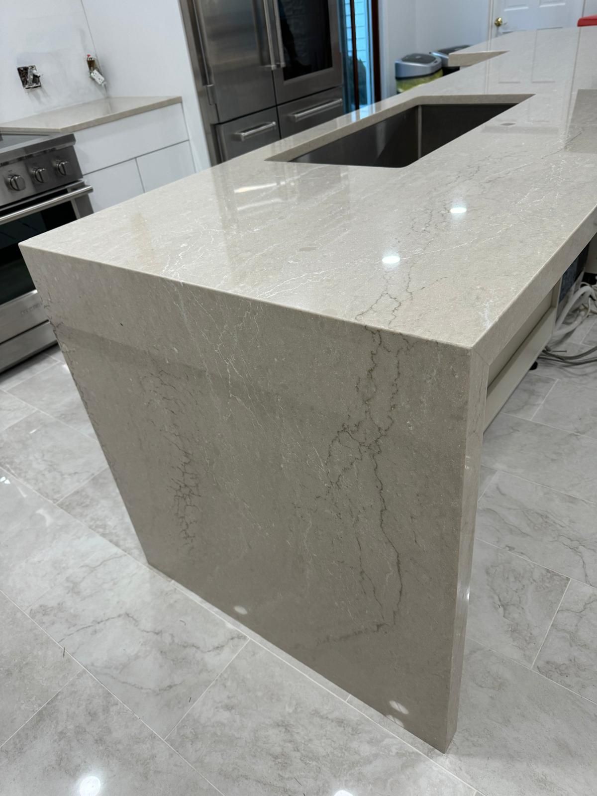Close-up of a kitchen island with a light-colored countertop and built-in sink.