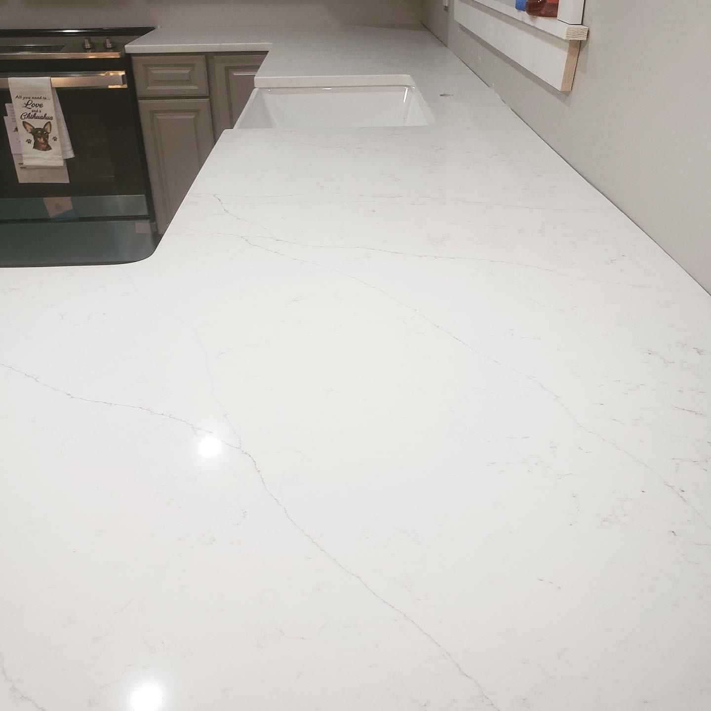 White quartz countertop with subtle veining in a kitchen.