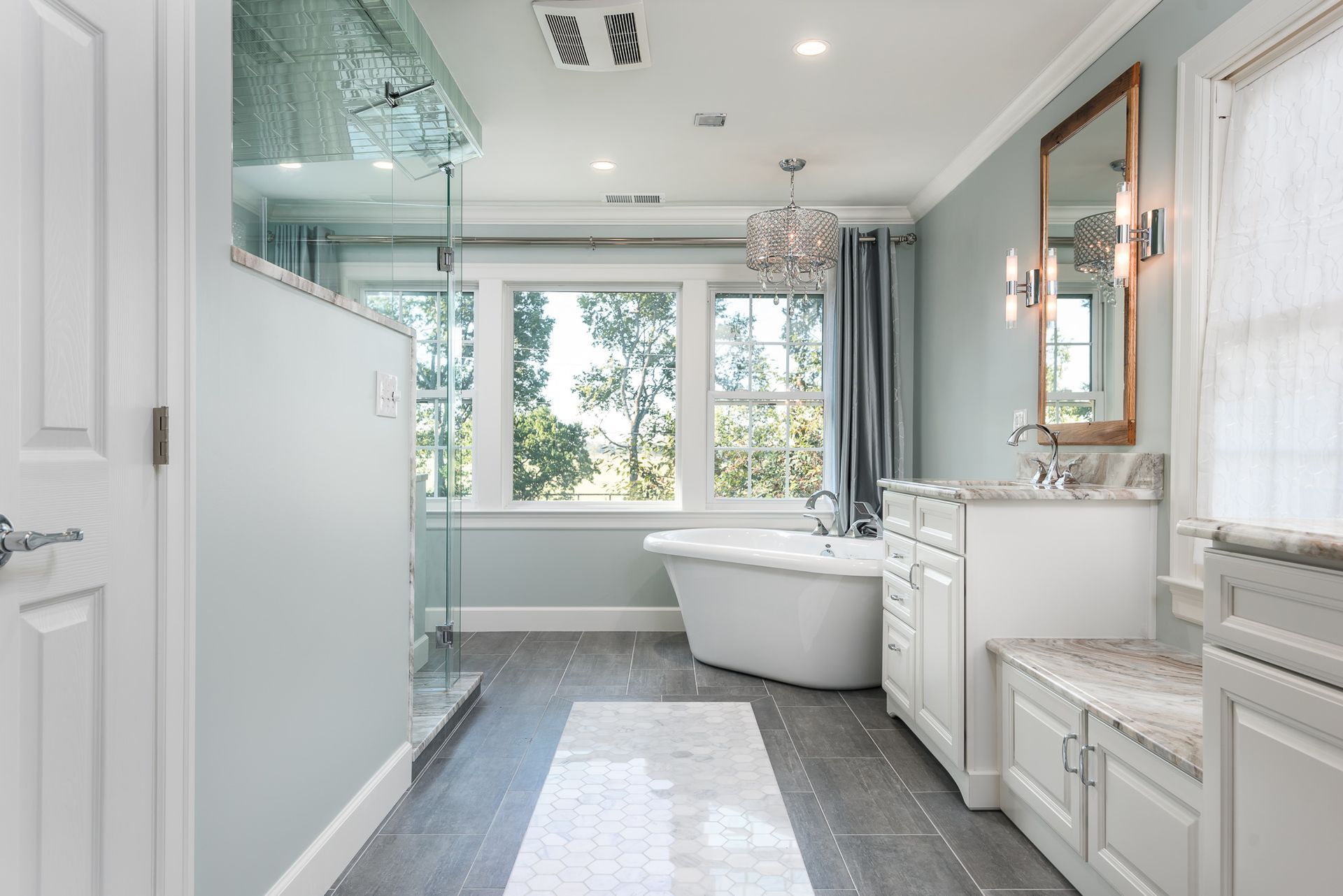 A bathroom with a tub , sinks , mirrors and a walk in shower.