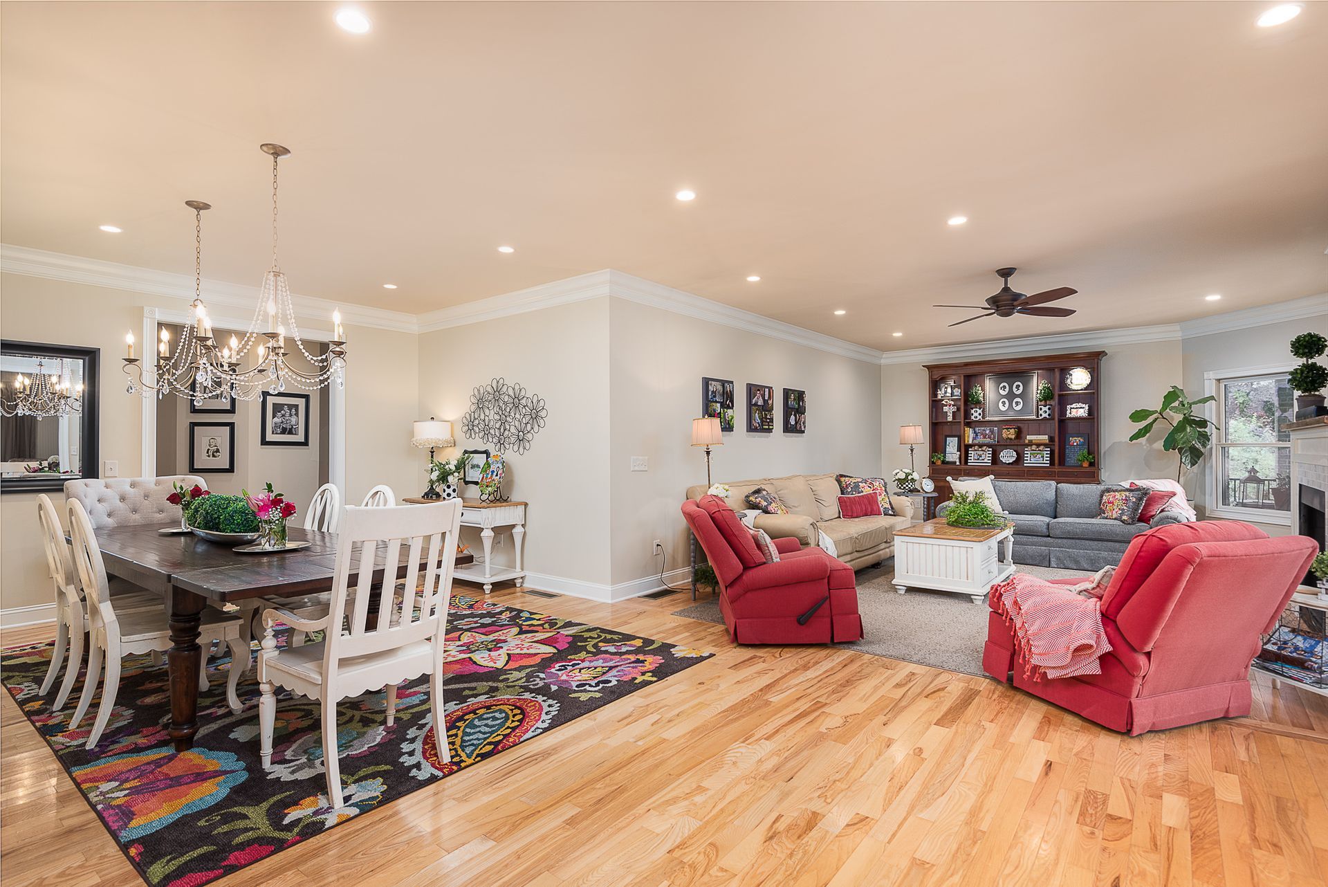 A living room with hardwood floors , a dining room table , chairs and a couch.