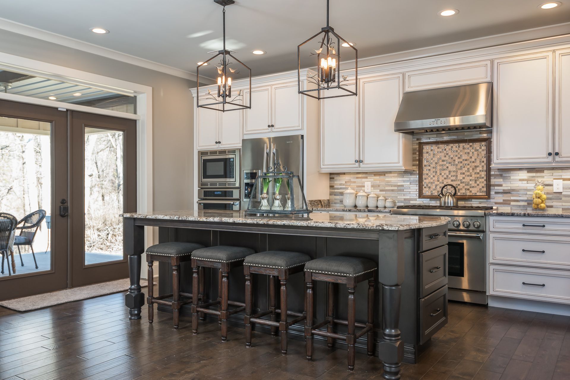 A kitchen with white cabinets and stainless steel appliances and a large island.