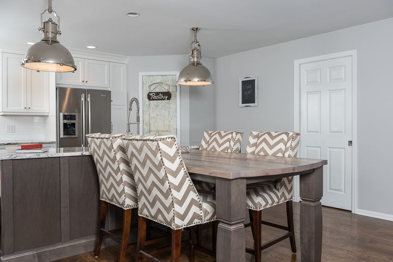 A kitchen with a dining table and chairs and a refrigerator.