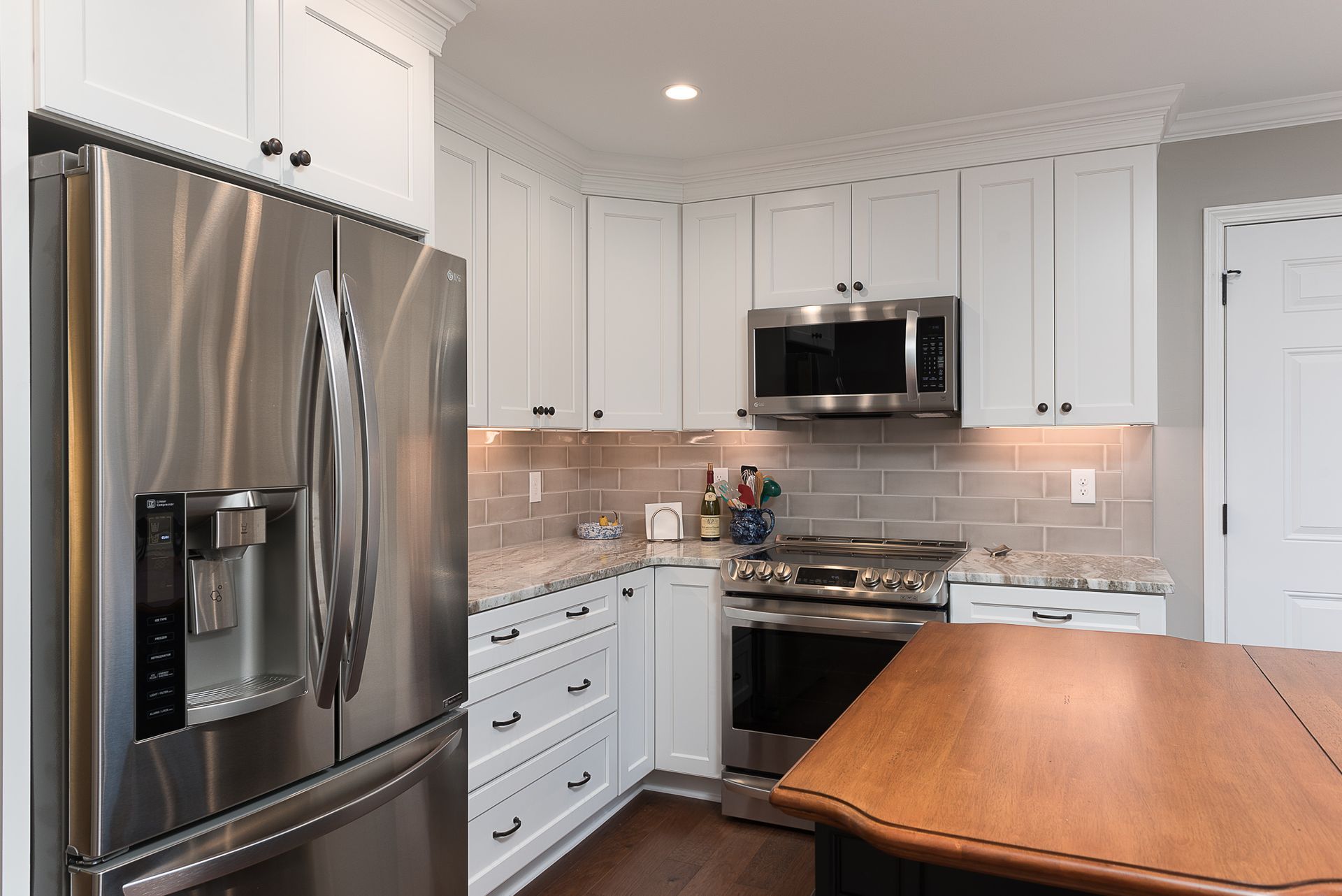 A kitchen with stainless steel appliances and white cabinets