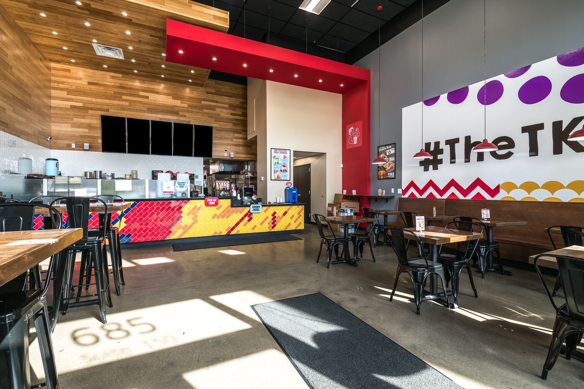 A restaurant with tables and chairs and a mural on the wall.