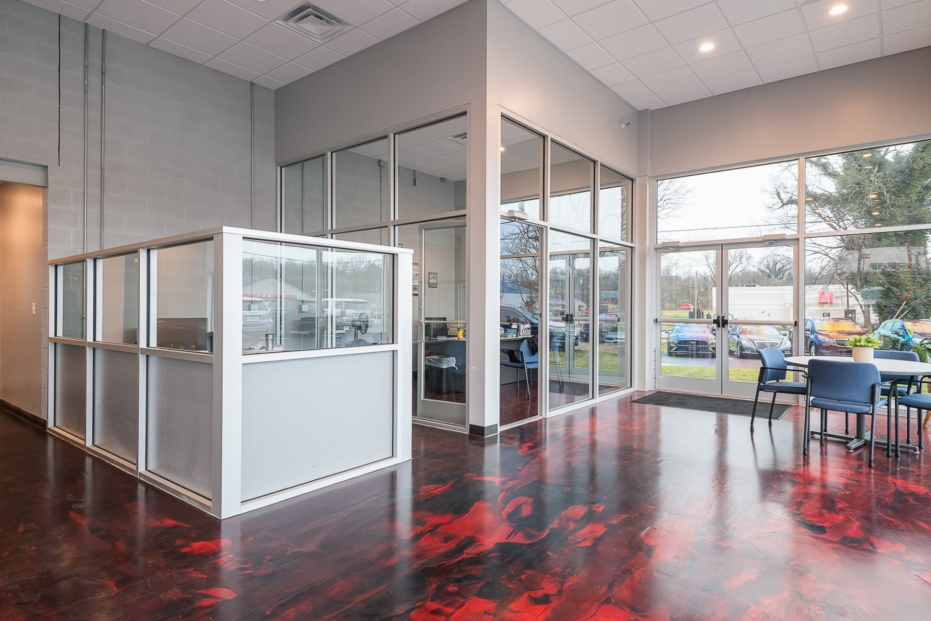 A large room with tables and chairs and a red floor.