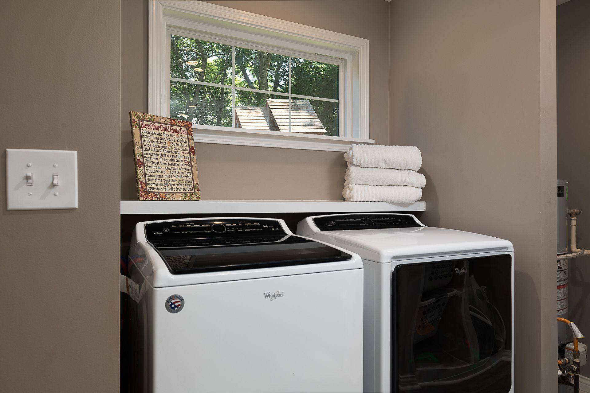 A laundry room with a washer and dryer and a window.