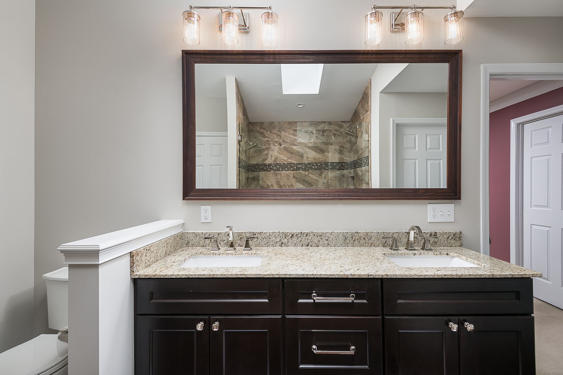A bathroom with two sinks and a large mirror.